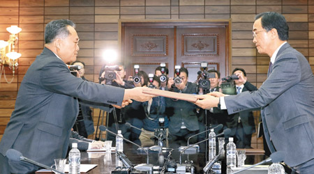 北韓代表李善權（左）與南韓代表趙明均（右）在會上交換協議文件。（美聯社圖片）