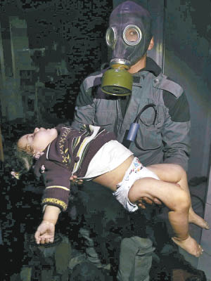 戴防毒面罩的救援人員，抱起一名遭化武襲擊的兒童。（美聯社圖片）
