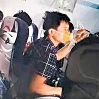 機上乘客紛紛戴上氧氣罩。