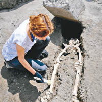 骸骨平躺在地上，頭顱及胸部被大石壓碎。（美聯社圖片）
