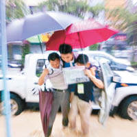 深圳有學校職員與家長一同揹學生涉水入考場。