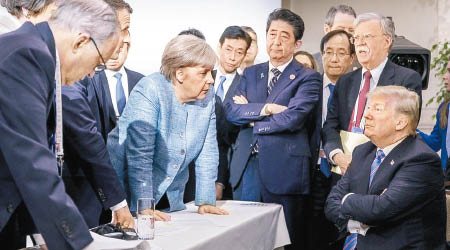 美國因關稅問題與歐盟鬧僵，德國總理默克爾（左二）在G7峰會責問特朗普（右）。（美聯社圖片）