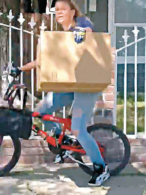 該名女子抱住偷來的包裹，想騎單車離去。