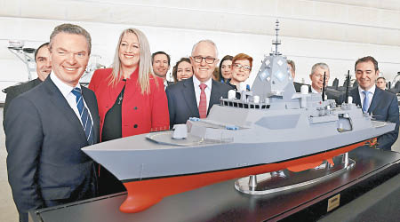 特恩布爾（前排左三）與官員展示護衞艦模型。（美聯社圖片）