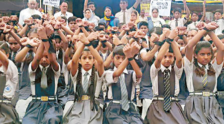 學童舉起綑綁的雙手，譴責強姦案。（互聯網圖片）