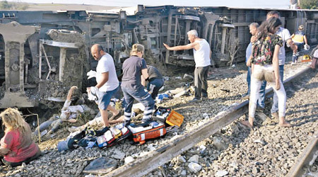 列車出軌翻側，不少受傷乘客在地上待救。（美聯社圖片）