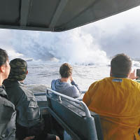 遊客乘船近距離觀看岩漿流入大海的奇景。（美聯社圖片）
