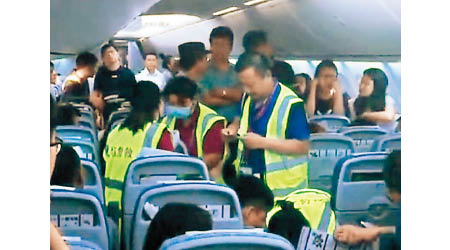 醫護人員登機為暈倒乘客急救。（互聯網圖片）