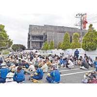 工人在附近停車場避難。（美聯社圖片）