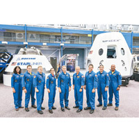 九名太空人與CST-100 Starliner（左後）及龍號（右後）太空船合照。（美聯社圖片）