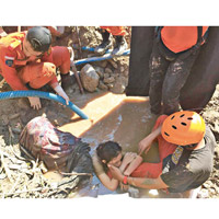 搜救人員抽出積水，救出一名女士。（美聯社圖片）
