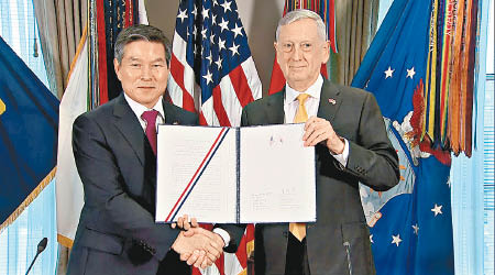 鄭景斗（左）與馬蒂斯（右）簽署《聯合防衞方針》。（美聯社圖片）