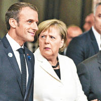 馬克龍（左）及默克爾（右）一起出席巴黎和平論壇。