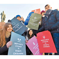 烏克蘭學生手持寫有「保持冷靜」的標語牌。