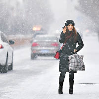 新疆<br>新疆喀什市雪花紛飛，市民在路邊等的士。