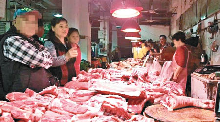 老翁（左）於肉檔購買豬肉帶過境。