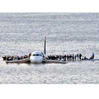 客機迫降河面後，眾人在機翼上等待救援。