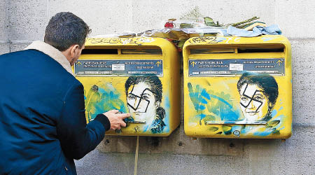 藝術家協助清理遭塗鴉的郵箱。（美聯社圖片）
