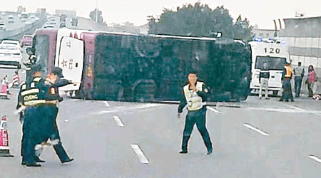 旅遊巴翻側在路上，車尾窗碎裂。（讀者提供）