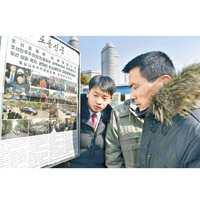 北韓民眾觀看金正恩訪越的新聞複製本。