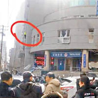 發生爆炸後，有一人爬出大樓外牆（紅圈示），搖搖欲墜。