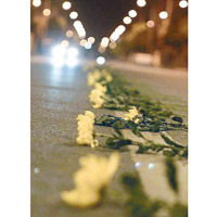 悼念死者的鮮花整齊有序放在路上。