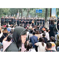 一批示威者在行人路靜坐，與警方對峙。