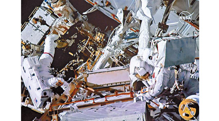 麥克萊恩（左）與聖雅克（右）為太空站的裝置加配部件。（美聯社圖片）