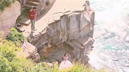 遊客在鑽石灣懸崖邊拍攝。（電視畫面）