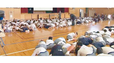 地震發生時，一批學童伏在地上、雙手保護頭部。（電視畫面）