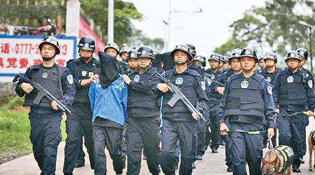 大批警員荷槍實彈押解疑犯。（互聯網圖片）