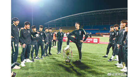 一名南韓球員腳踩獎盃，其他隊員大笑和應。（互聯網圖片）