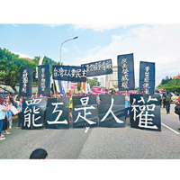 示威者手持橫額及標語，在台北遊行。