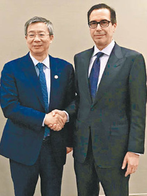 易綱（左）與姆紐欽（右）於G20會面時握手。