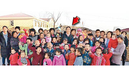 李利娟（箭嘴示）與愛心村的孤兒合照。（互聯網圖片）
