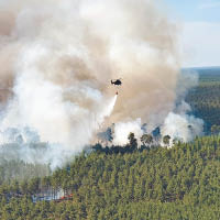 德國：德國警方的直升機在起火的森林灑水。（美聯社圖片）