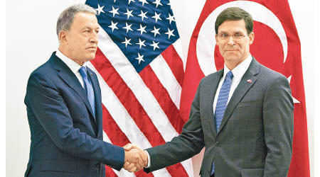土耳其防長阿卡爾（左）在北約會議上與埃斯珀（右）握手。（美聯社圖片）