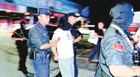 劉永才（白衣男）被警方逮捕。