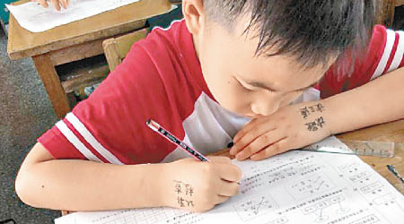 男童左手背寫上「題目看兩遍」五個大字。（互聯網圖片）