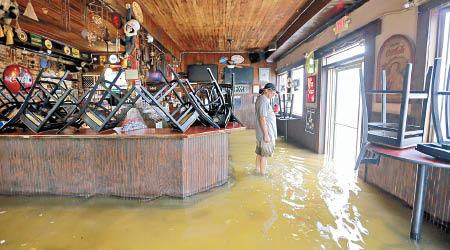 洪水湧入商店。（美聯社圖片）