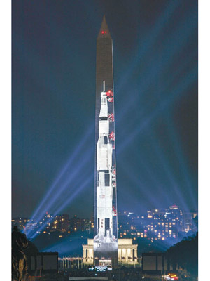 首都華盛頓紀念碑上投影出曾用於太陽神登月計劃的土星五號火箭圖像。（美聯社圖片）