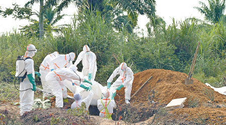 工作人員埋葬死於伊波拉病毒的民眾遺體。（美聯社圖片）