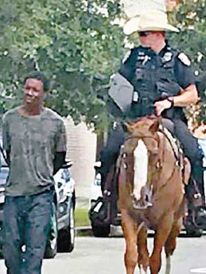 白人騎警用繩扣住黑人疑犯遊街示眾。（互聯網圖片）
