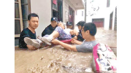 救援人員在洪水中抬居民離開。（互聯網圖片）