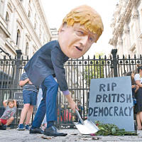 示威者在唐寧街戴上約翰遜頭套，諷刺「民主已死」。