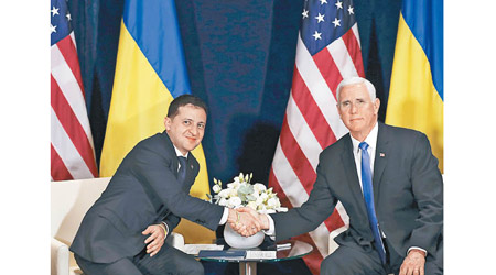 澤連斯基（左）與彭斯（右）握手。（美聯社圖片）