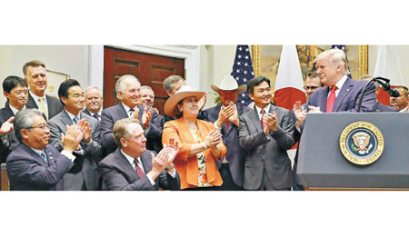 在特朗普（右）見證下，美日代表簽署貿易協定。（美聯社圖片）