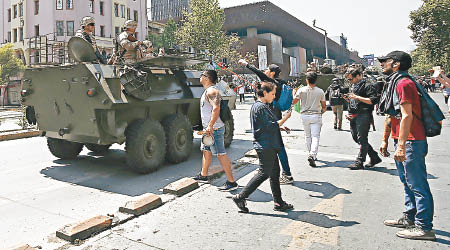 有示威者向坦克上的軍人對質。（美聯社圖片）