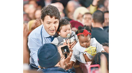 杜魯多（左）於拉票活動與嬰兒合照。