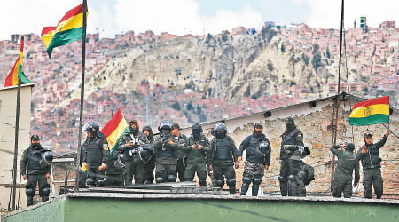 倒戈警員於警局屋頂揮舞國旗。（美聯社圖片）
